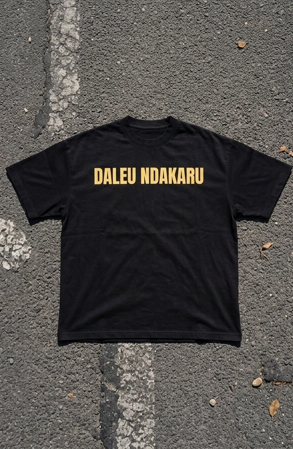Face du T-shirt noir DALEU NDAKARU, inscription sable-doré sur la poitrine